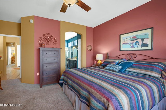 carpeted bedroom featuring ensuite bathroom and ceiling fan