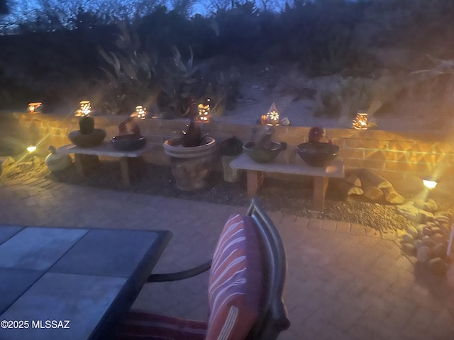 pool at night featuring a patio