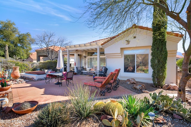 rear view of property with a jacuzzi, a patio area, and a pergola