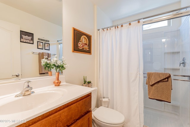 bathroom featuring walk in shower, vanity, and toilet