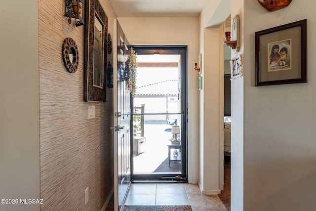 doorway to outside with light tile patterned flooring