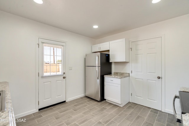 kitchen with stainless steel fridge and white cabinets