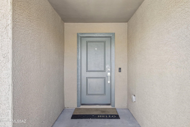 property entrance with stucco siding