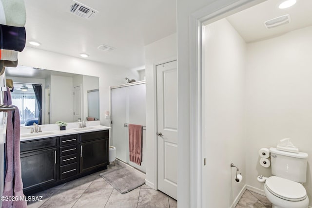 full bath featuring toilet, a sink, visible vents, and a shower stall