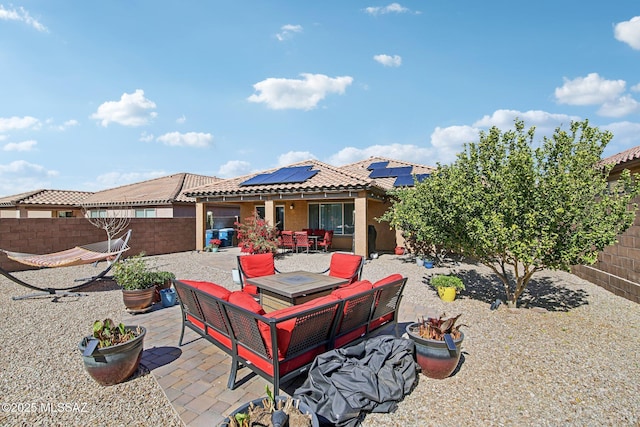 exterior space with a patio, a fenced backyard, a tiled roof, roof mounted solar panels, and stucco siding