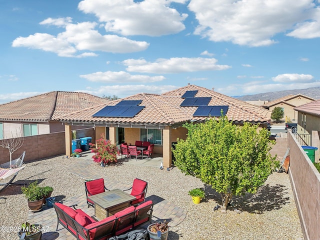 rear view of property featuring solar panels, a fenced backyard, a patio area, an outdoor living space, and stucco siding