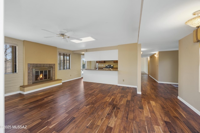 unfurnished living room with dark hardwood / wood-style floors and ceiling fan