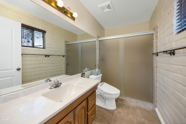 bathroom featuring vanity, walk in shower, toilet, and brick wall