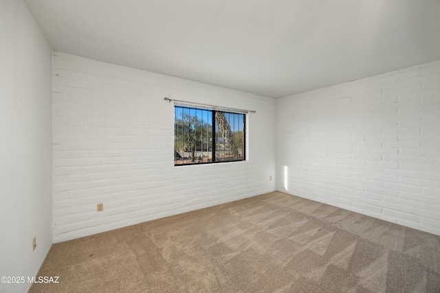 empty room with brick wall and carpet floors