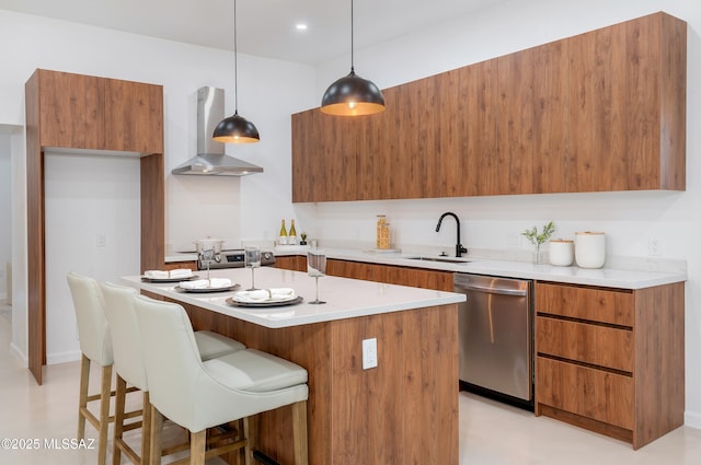 kitchen with decorative light fixtures, sink, a center island, stainless steel dishwasher, and wall chimney range hood