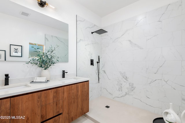 bathroom featuring tiled shower and vanity