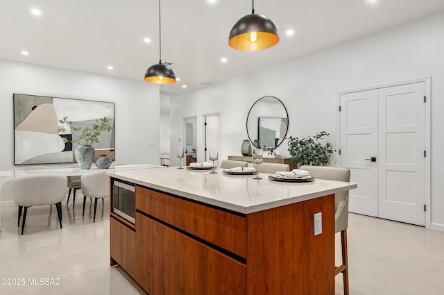 kitchen featuring a breakfast bar, hanging light fixtures, and a kitchen island