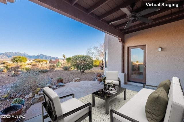 view of patio with an outdoor living space, a mountain view, and ceiling fan