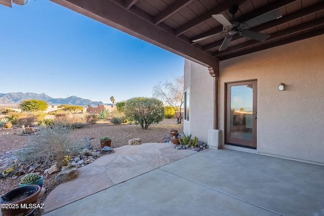 view of patio / terrace with a mountain view and a ceiling fan