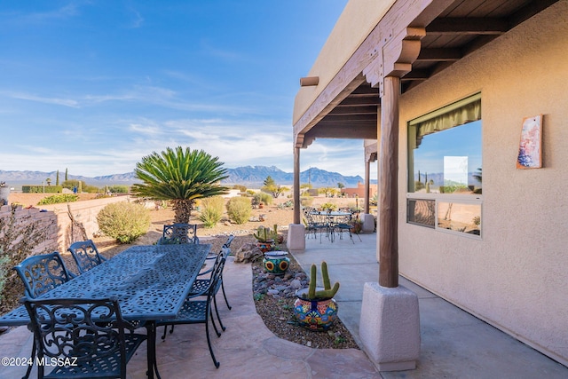 view of patio / terrace featuring outdoor dining space and a mountain view