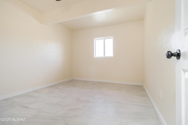 spare room featuring beam ceiling