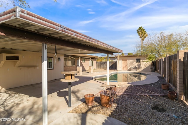 back of house featuring a fenced in pool, a patio area, and a storage unit