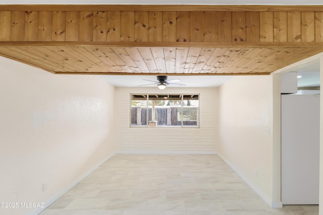 spare room featuring brick wall, wood ceiling, and ceiling fan