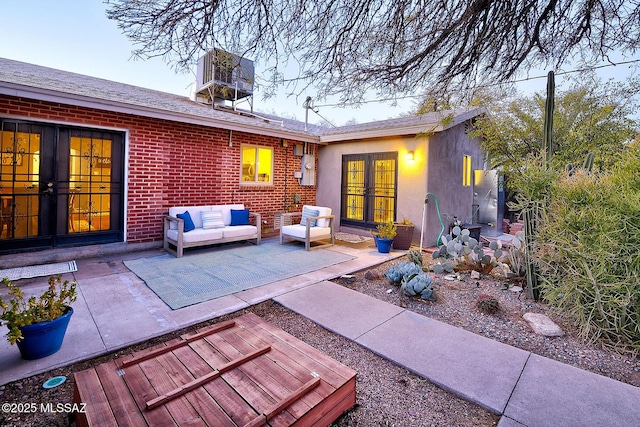 rear view of house with an outdoor living space, a patio area, french doors, and central air condition unit