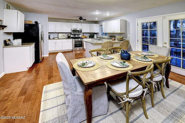 dining space featuring french doors, ceiling fan, light hardwood / wood-style floors, and sink