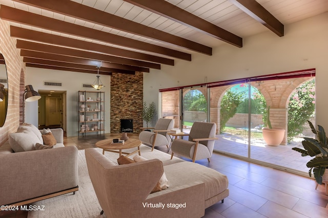 living room featuring a stone fireplace, wooden ceiling, and beamed ceiling