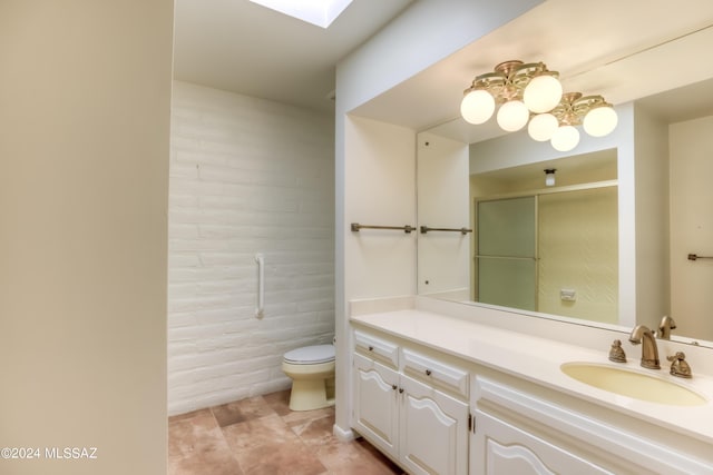 bathroom featuring a skylight, vanity, tile patterned floors, toilet, and walk in shower