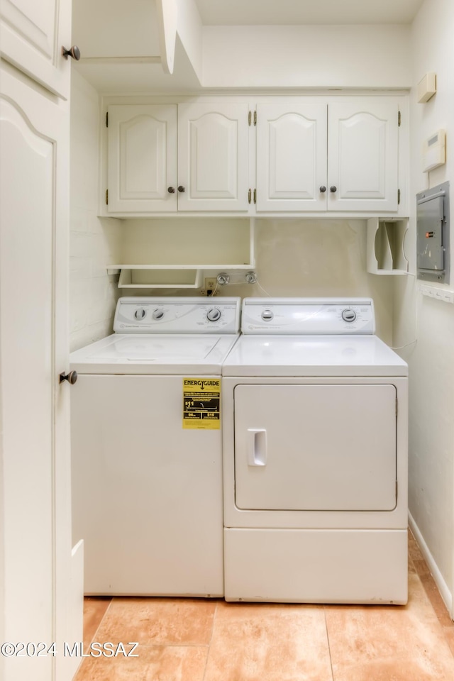 washroom featuring independent washer and dryer, cabinets, electric panel, and light tile patterned floors