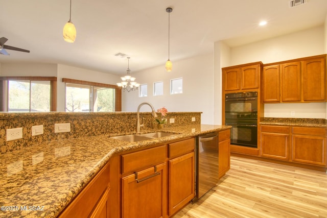 kitchen featuring hanging light fixtures, dishwasher, sink, and double oven