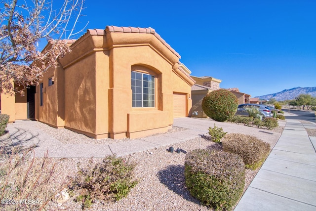 view of side of property with a garage and a mountain view