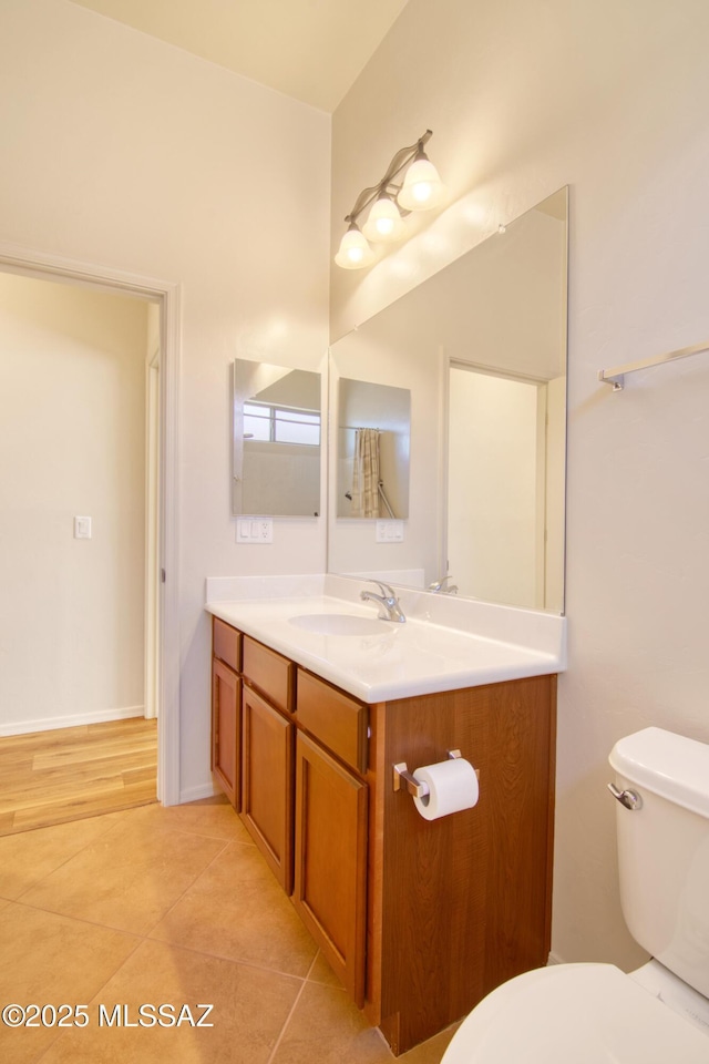 bathroom featuring vanity, tile patterned flooring, and toilet