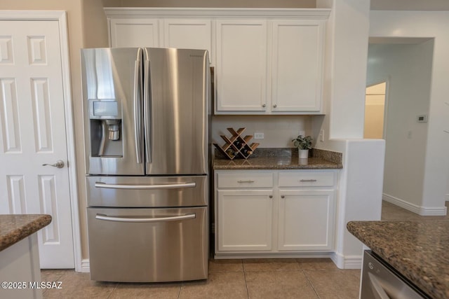 kitchen with white cabinetry, appliances with stainless steel finishes, and dark stone counters