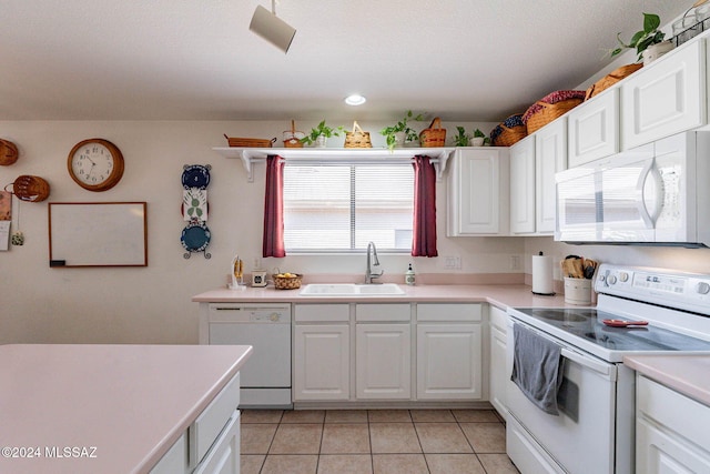 kitchen featuring white cabinetry, sink, light tile patterned floors, and white appliances