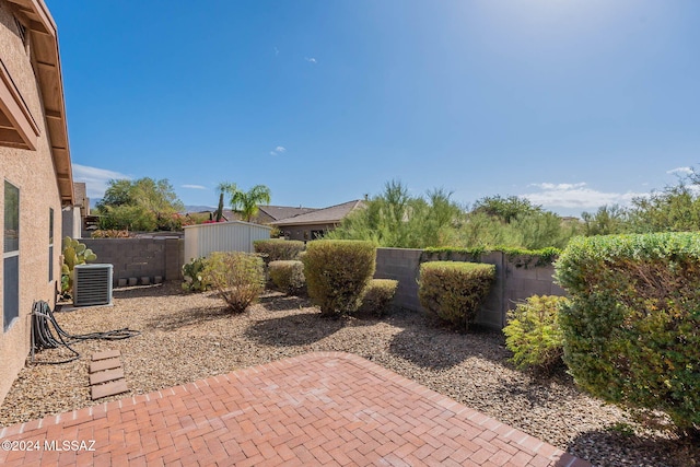 view of patio / terrace with central AC unit and a shed