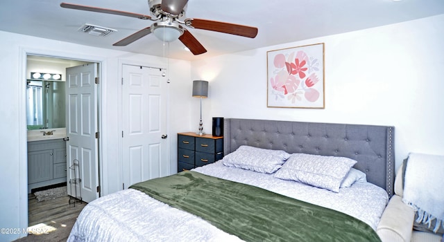 bedroom featuring ceiling fan, dark hardwood / wood-style floors, ensuite bath, and a closet