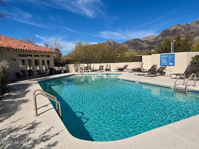 view of swimming pool with a mountain view and a patio area