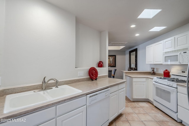 kitchen featuring white cabinetry, sink, white appliances, and kitchen peninsula