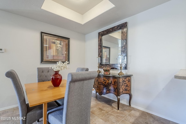 dining room featuring tile patterned floors and a raised ceiling