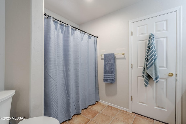 bathroom with walk in shower, tile patterned floors, and toilet