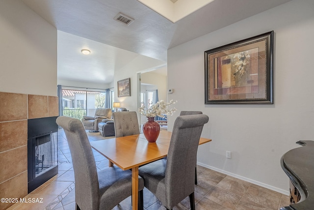 tiled dining room featuring a fireplace