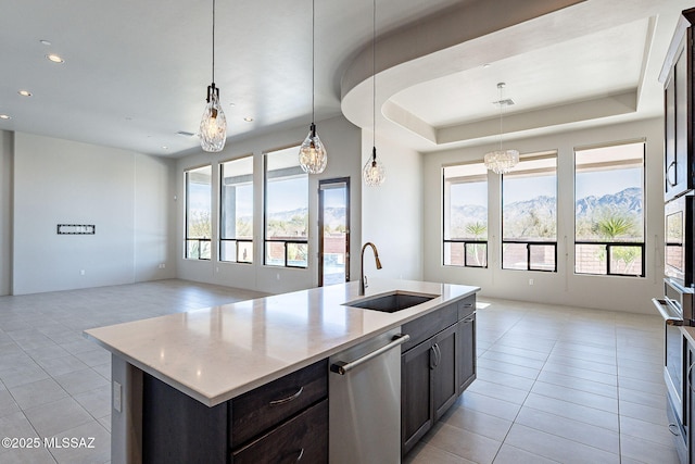 kitchen featuring open floor plan, light countertops, a sink, and a kitchen island with sink