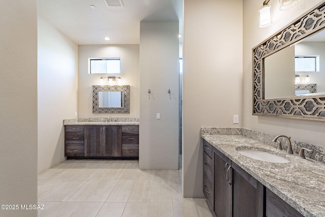 full bath featuring two vanities, a sink, visible vents, and tile patterned floors