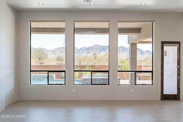 unfurnished room with recessed lighting, visible vents, a mountain view, and light tile patterned flooring