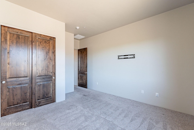 unfurnished bedroom featuring carpet, a closet, and visible vents