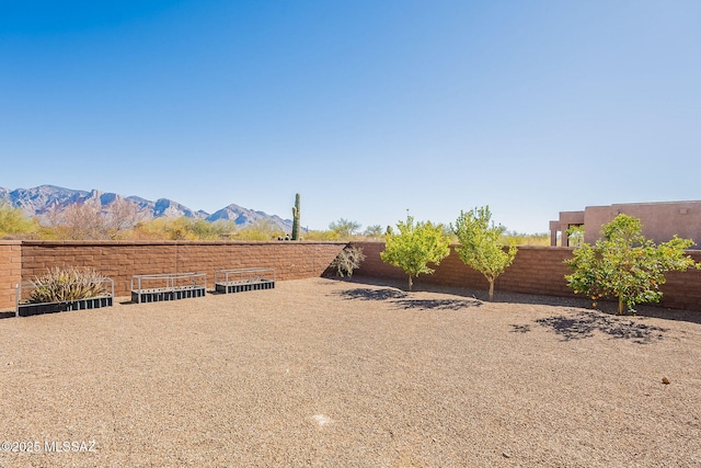 view of yard featuring fence and a mountain view