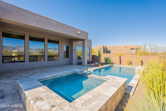 view of pool with a fenced backyard and a pool with connected hot tub