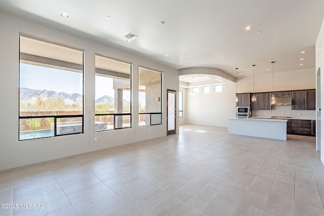 unfurnished living room with visible vents, light tile patterned floors, a mountain view, and recessed lighting