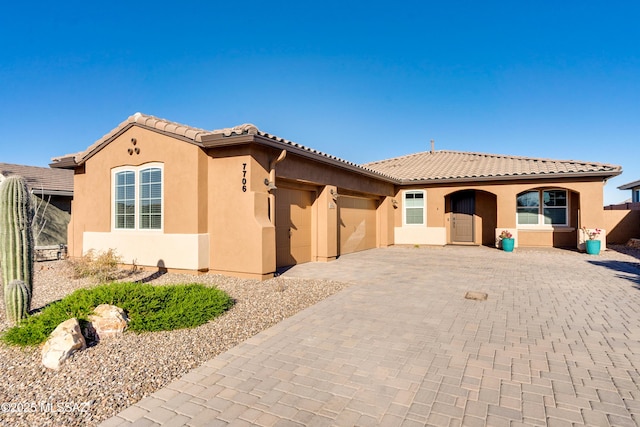 mediterranean / spanish home featuring a garage