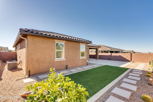 back of house with a yard, a patio area, and central air condition unit