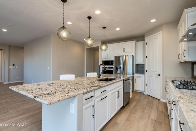 kitchen with a kitchen island with sink, white cabinetry, and stainless steel appliances