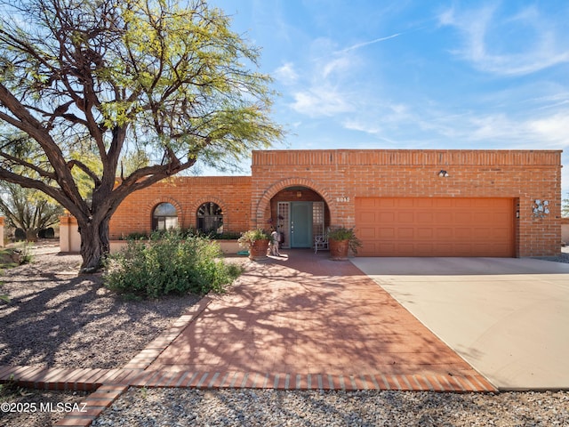 view of front property featuring driveway, a garage, and brick siding